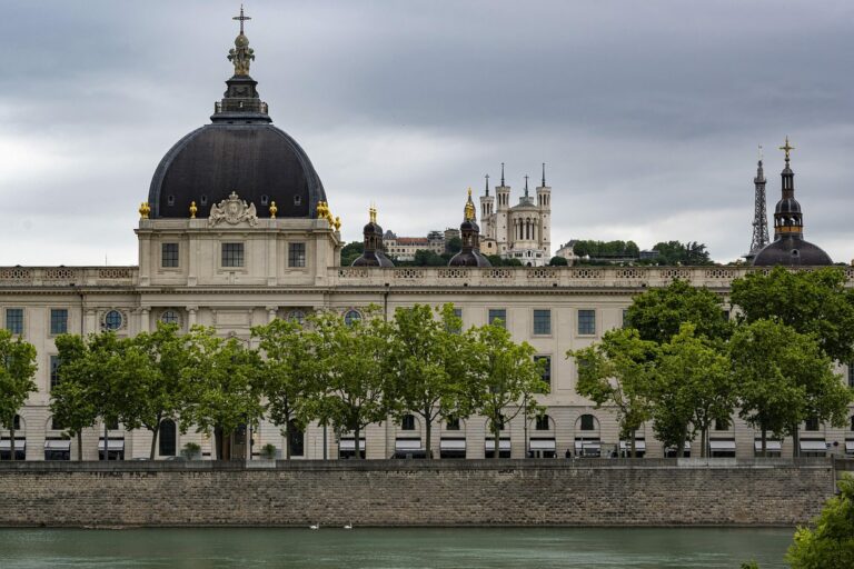 Le dôme et la façade du Grand Hôtel-Dieu de Lyon au bord du Rhône, sous un ciel nuageux