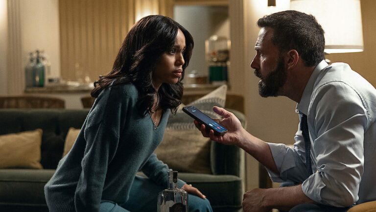Kerry Washington assise dans un salon face à Ben Affleck qui lui tend un téléphone, dans le film Animals