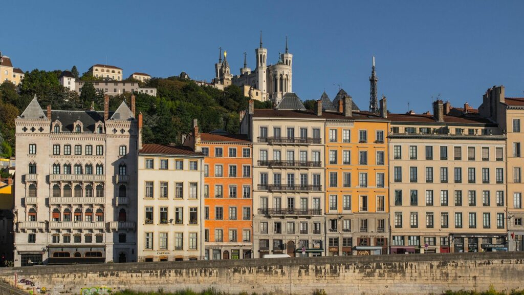 Façades colorées du quartier Saint-Jean au bord de la Saône, à Lyon, dominées par la basilique de Fourvière