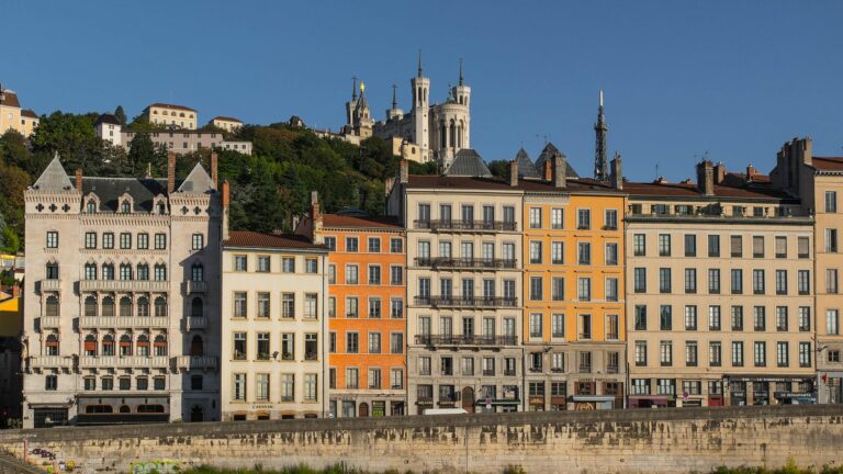 Façades colorées du quartier Saint-Jean au bord de la Saône, à Lyon, dominées par la basilique de Fourvière