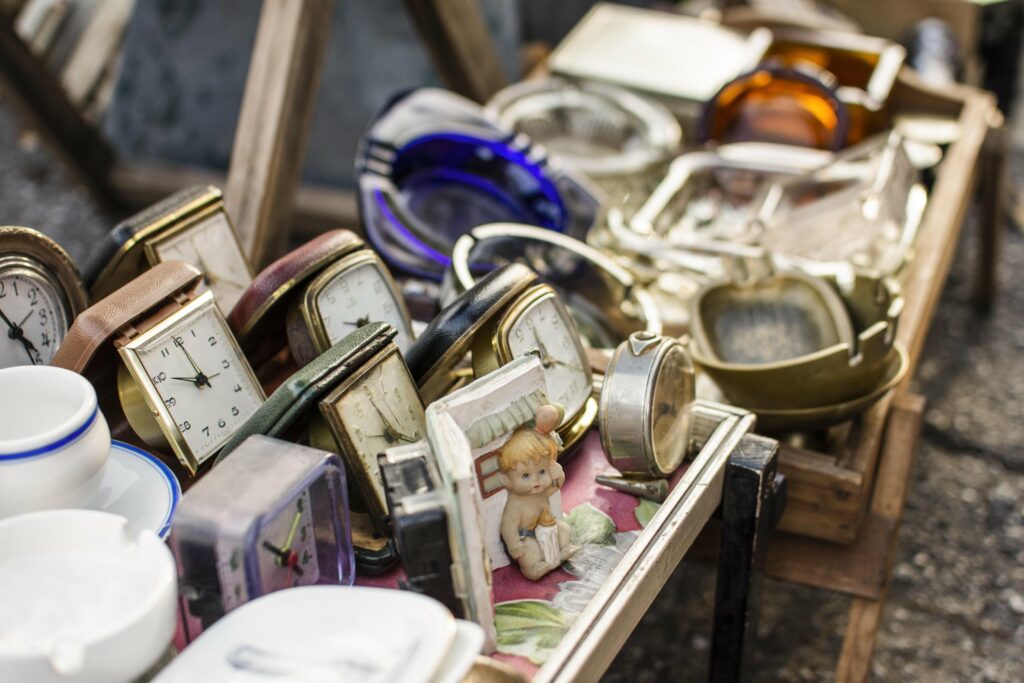 Horloges, théières et objets anciens sur un étal de brocante