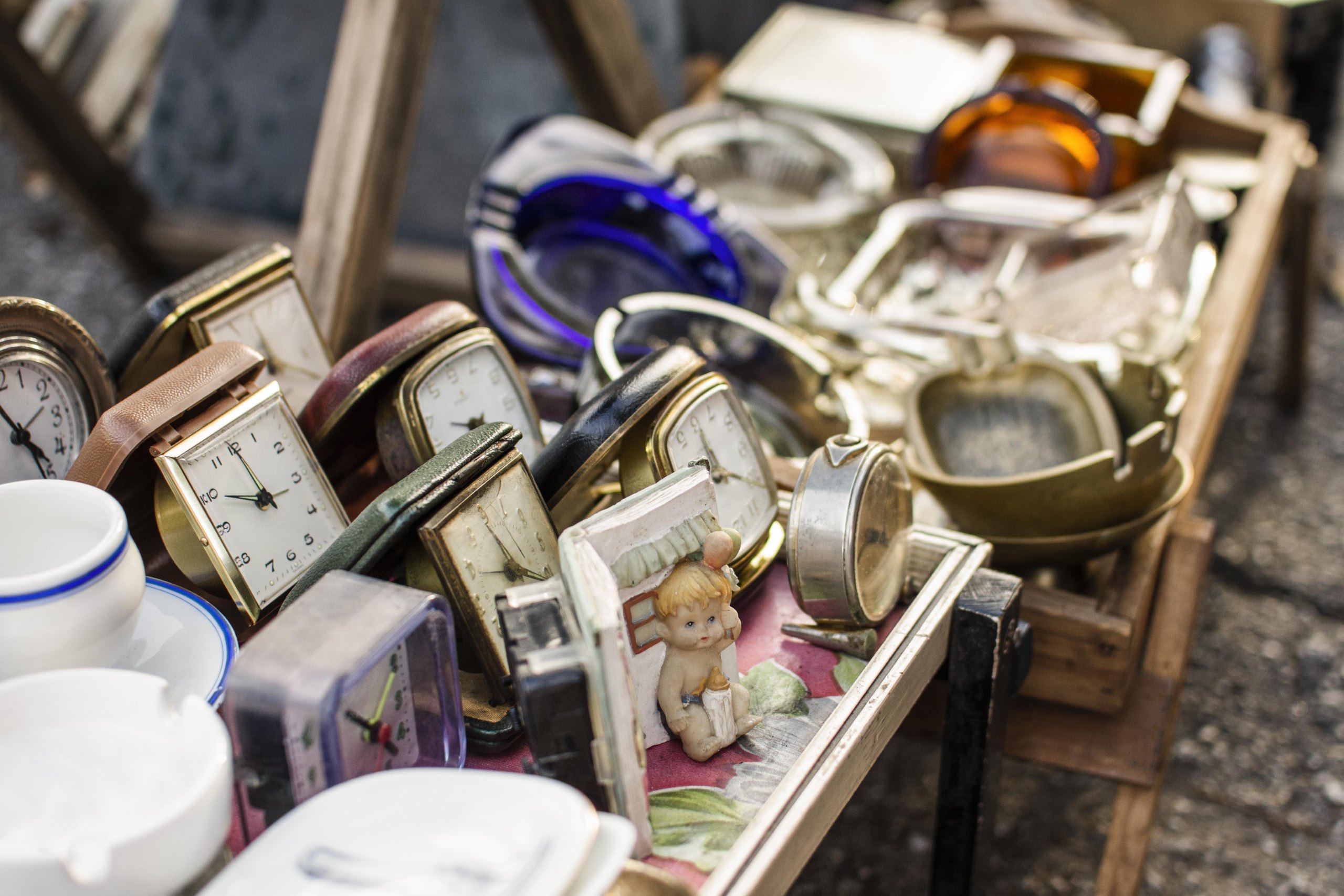 Horloges, théières et objets anciens sur un étal de brocante
