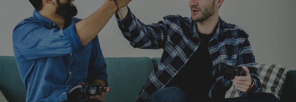 Deux joueurs manette en main se tapent dans la main devant un jeu vidéo