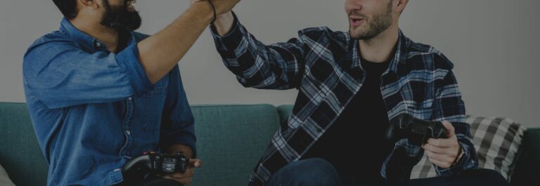 Deux joueurs manette en main se tapent dans la main devant un jeu vidéo