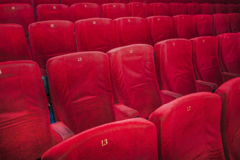 Rangées de fauteuils rouges dans une salle de cinéma
