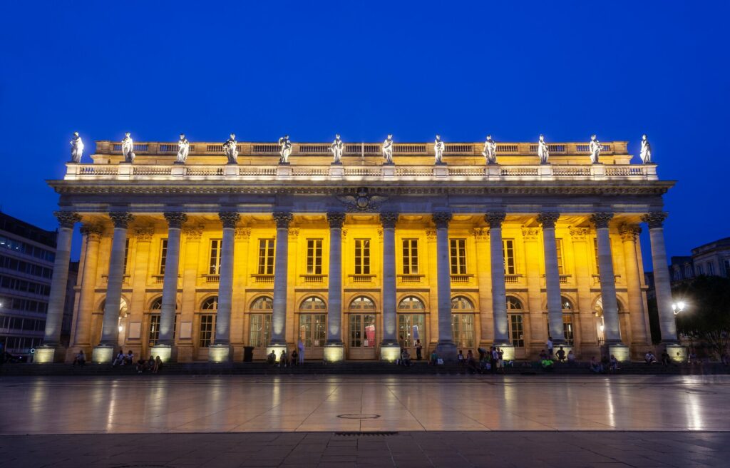 Façade illuminée du Grand-Théâtre de Bordeaux et sa colonnade, place de la Comédie, à la nuit tombée