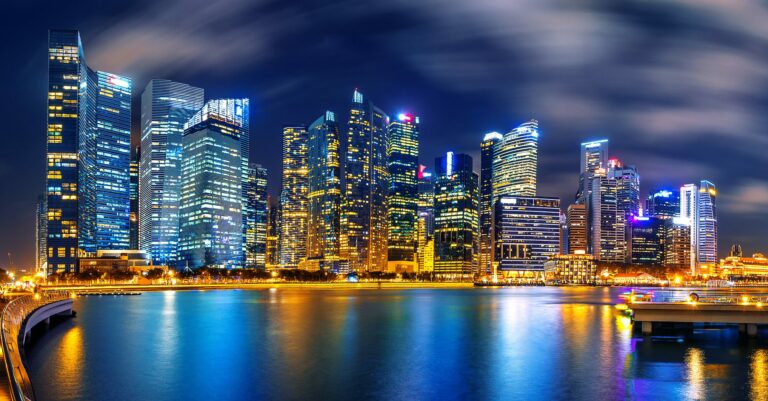 Gratte-ciel illuminés de Singapour se reflétant la nuit dans les eaux de la baie