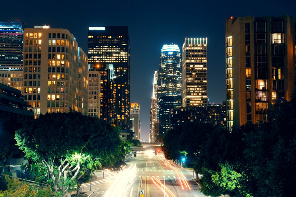 Rue du centre de Los Angeles la nuit, bordée de gratte-ciel éclairés