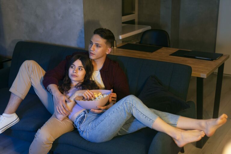 Couple installé dans un canapé devant une série en streaming