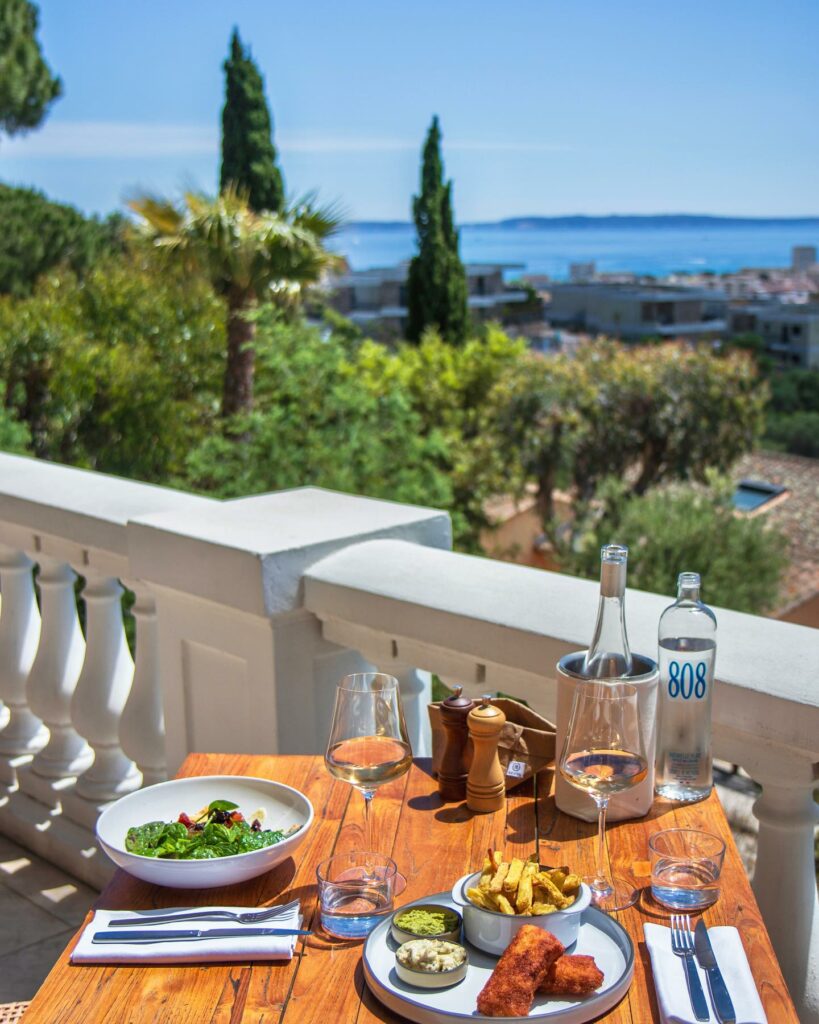 Table dressée sur la terrasse du Mirage, vue sur la baie de Bormes-les-Mimosas et les îles d'Or