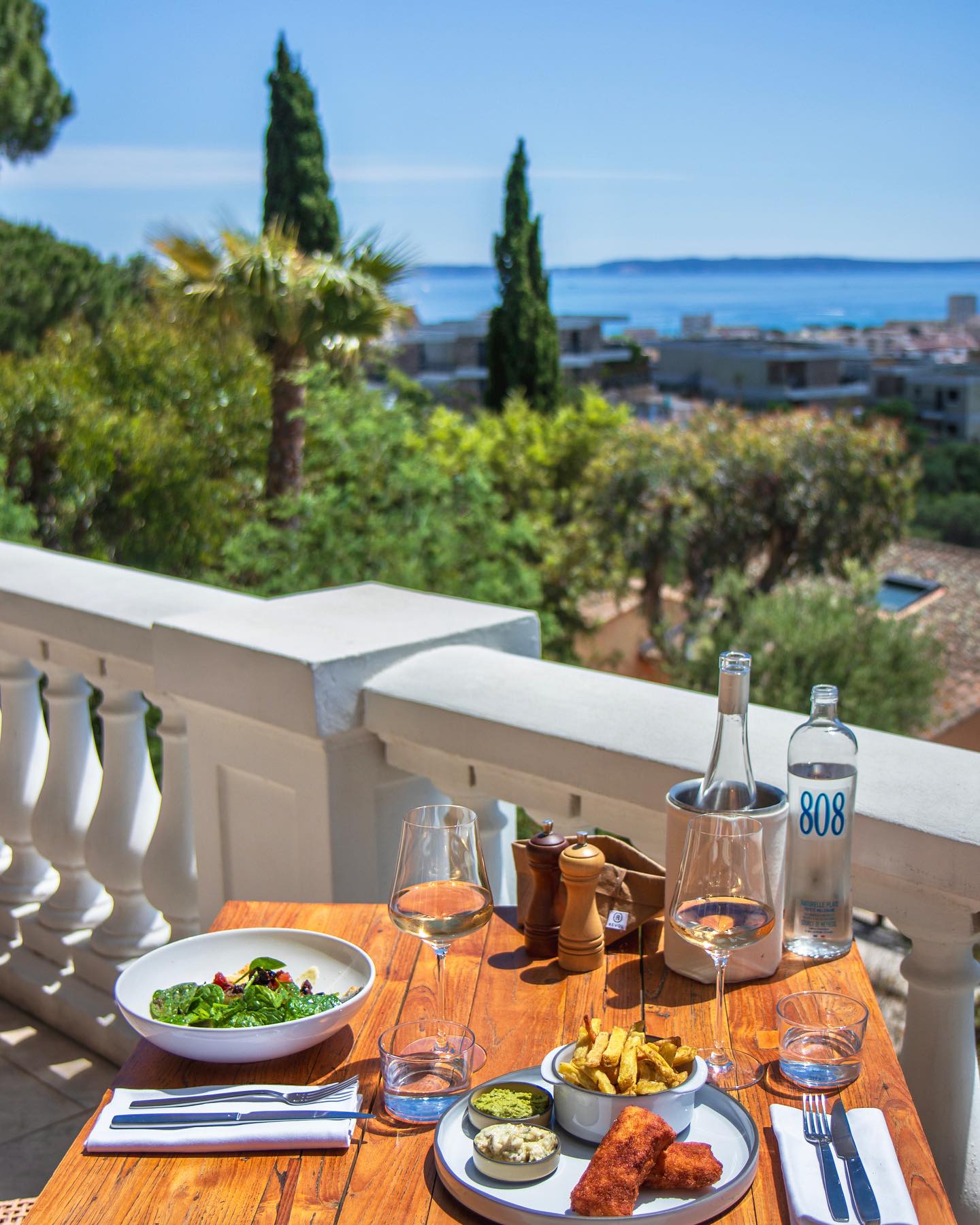 Table dressée sur la terrasse du Mirage, vue sur la baie de Bormes-les-Mimosas et les îles d'Or