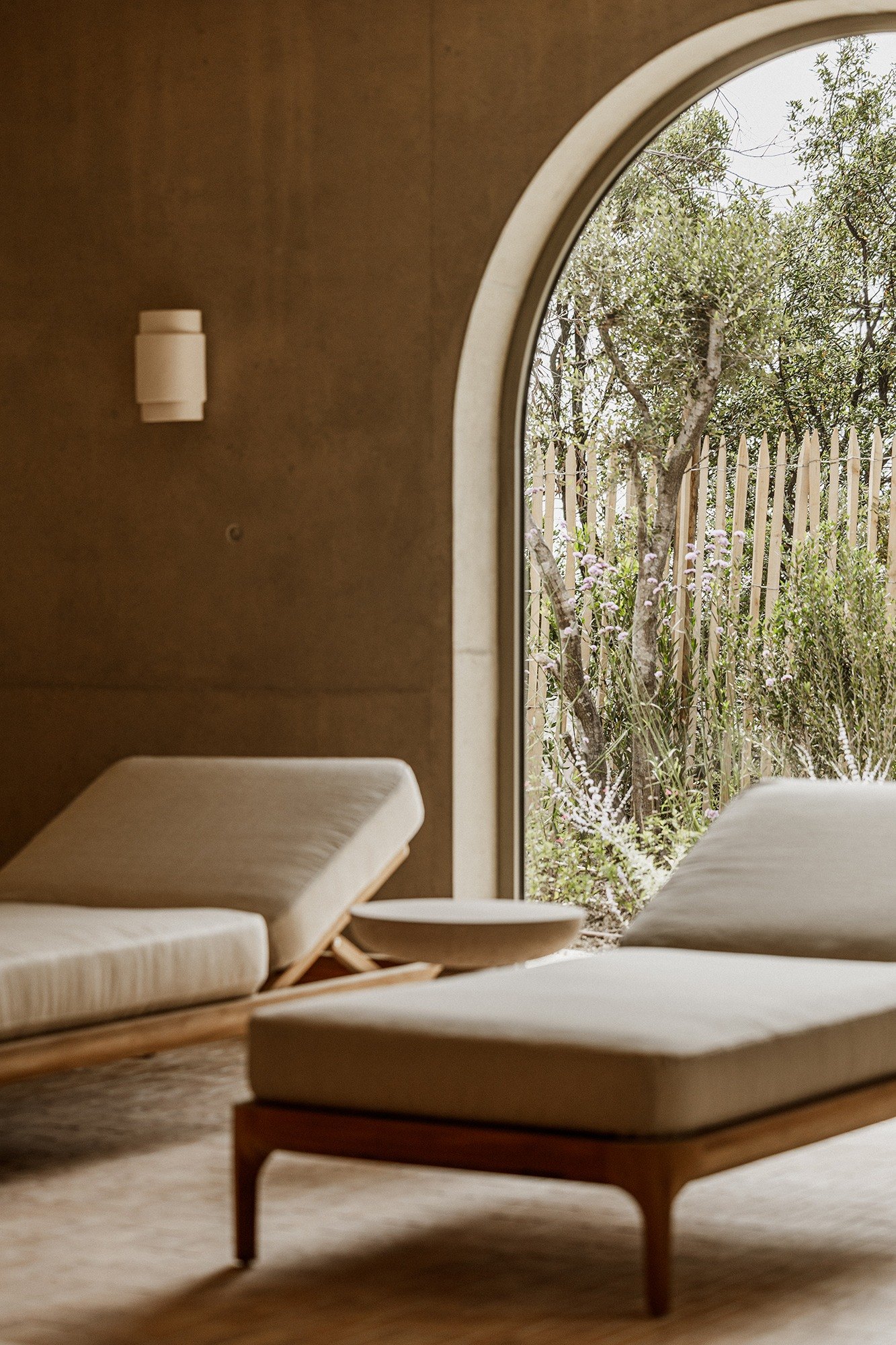 Chambre d'une villa du Mirage, baie en arche ouverte sur les pins