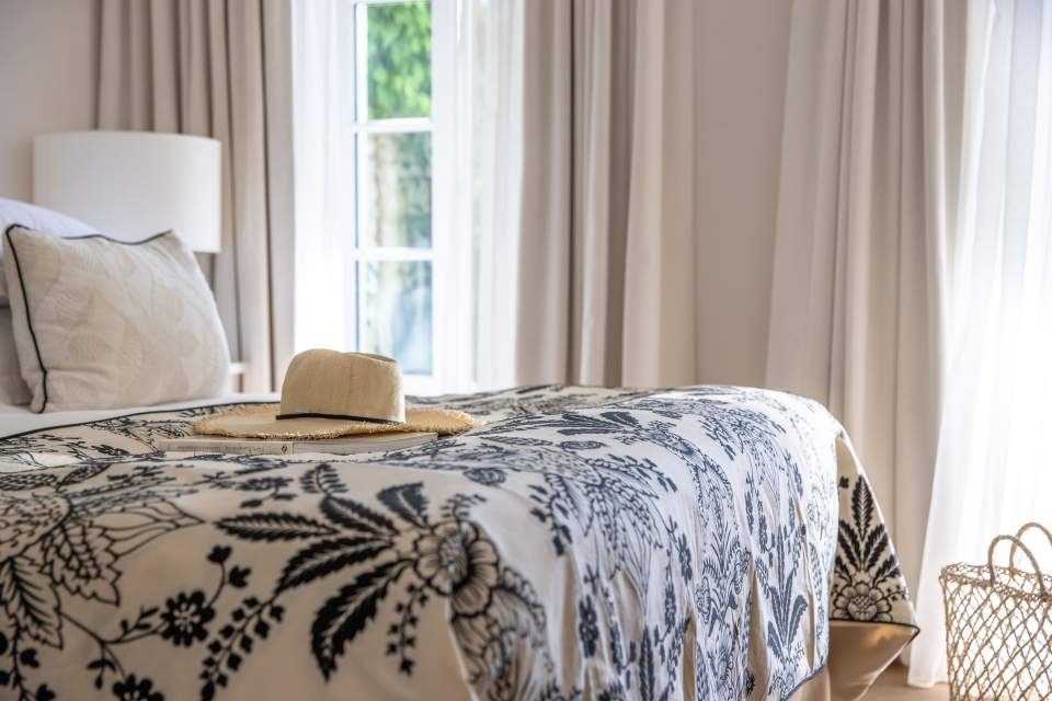 Chambre de la Villa Clarisse, lit habillé de lin et de velours, fenêtre sur le jardin
