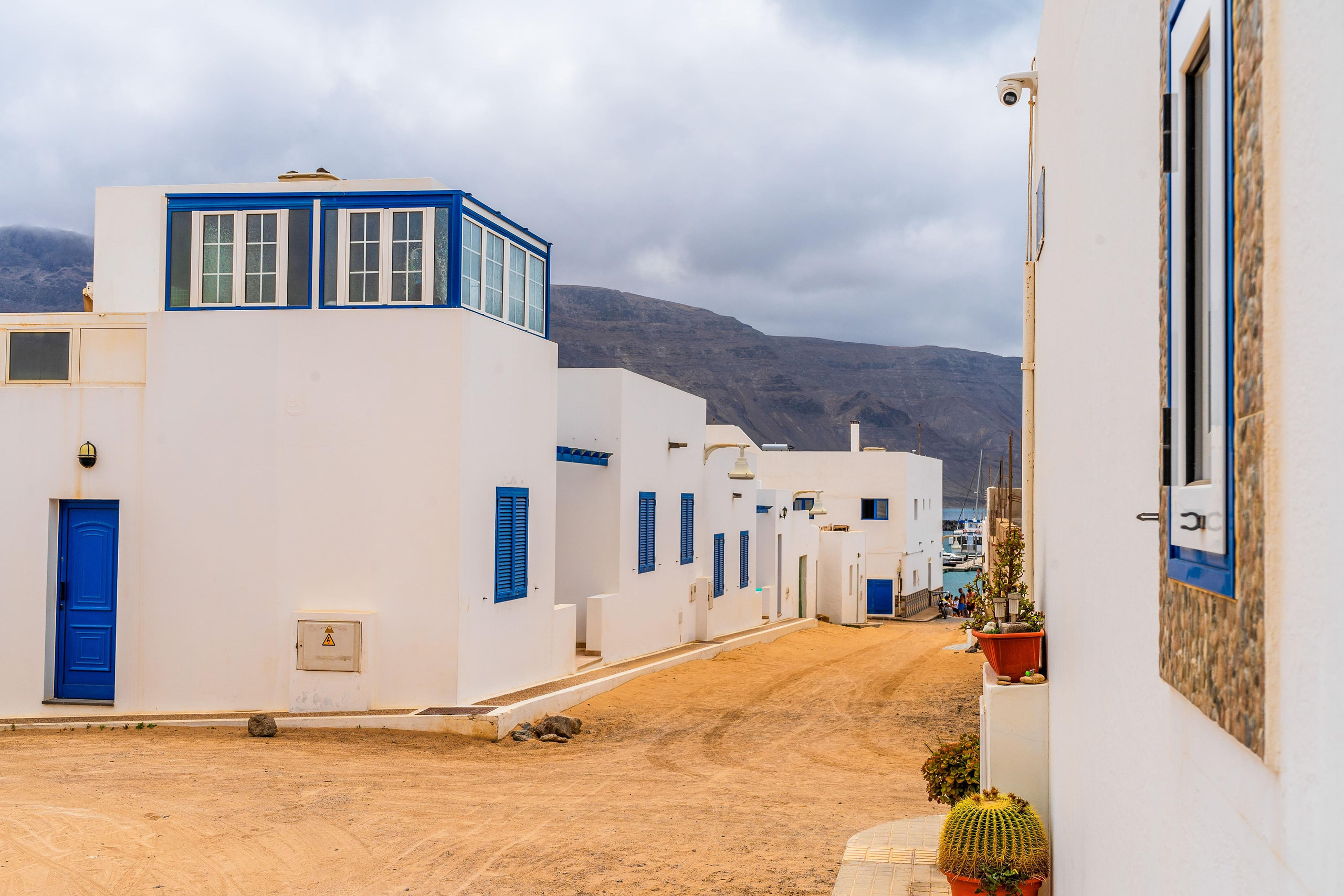 Maisons blanches aux portes et volets bleus dans une rue de sable de La Graciosa