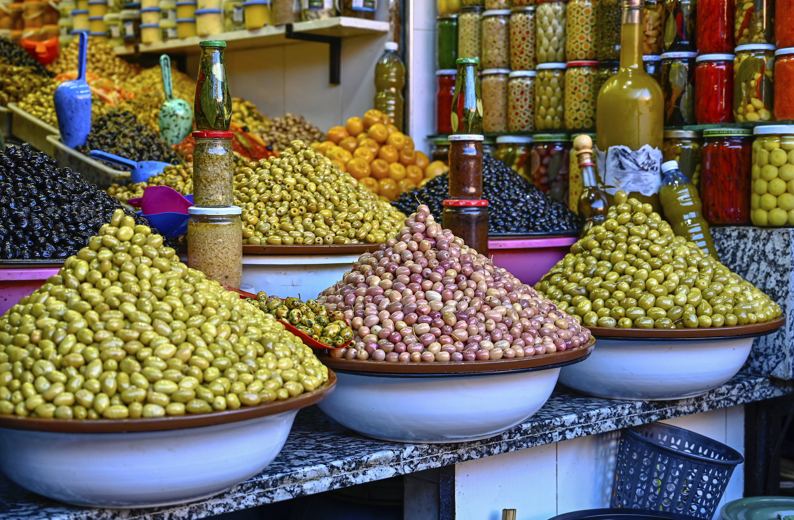 Pyramides d'olives vertes, violettes et noires sur un étal du souk de Marrakech