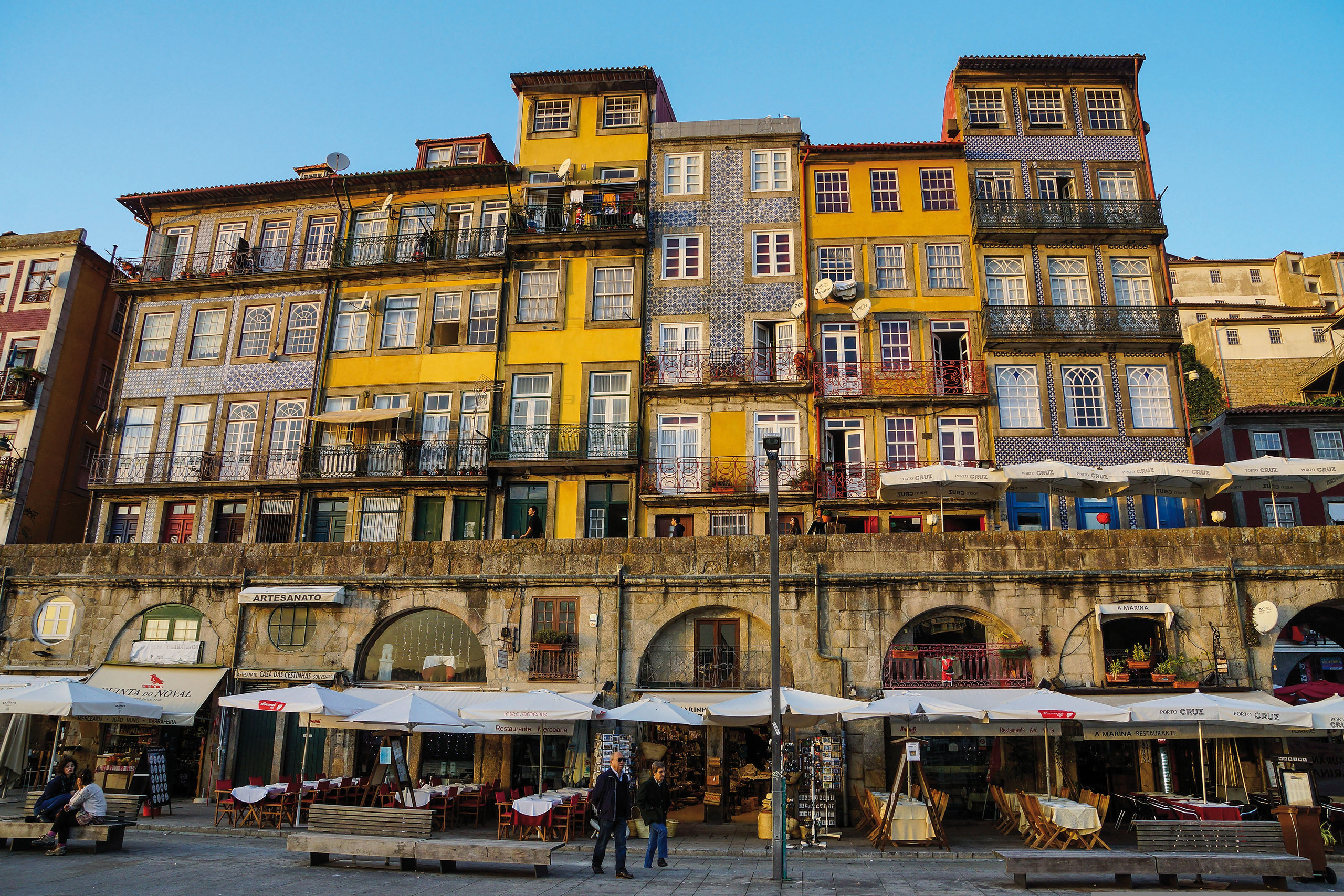 Façades colorées et terrasses de cafés sur le quai de la Ribeira à Porto