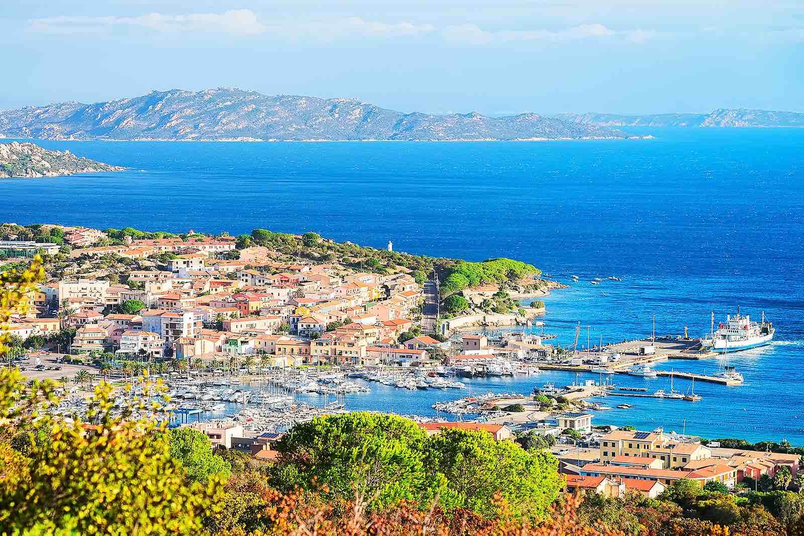 Village sarde en bord de mer avec son port de plaisance et les îles au large