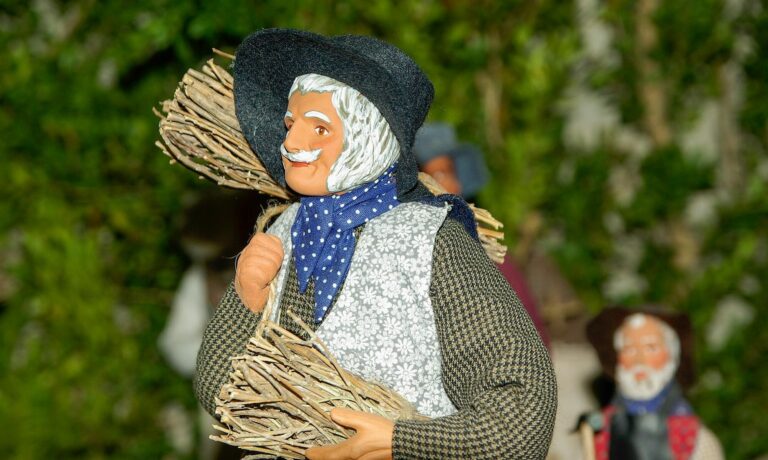 Santon provençal en argile représentant une paysanne au fichu et au panier, sur fond de verdure