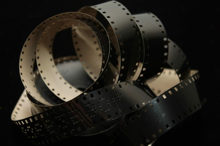 Pellicule de cinéma argentique déroulée sur un fond noir