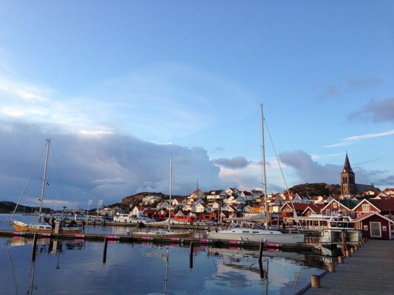 Port de plaisance de Fjällbacka au crépuscule, avec ses voiliers et ses maisons au pied de la falaise