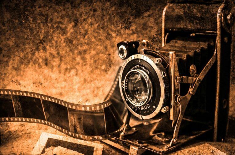 Appareil photo argentique ancien à soufflet posé sur des négatifs, dans des tons sépia