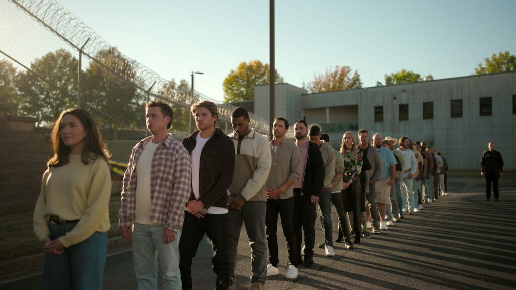 Les participants de The New Stanford Prison Experiment alignés le long d'une clôture barbelée