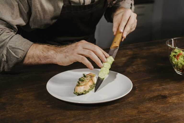 Un chef dressant une assiette dans une cuisine de restaurant, vue en plongée