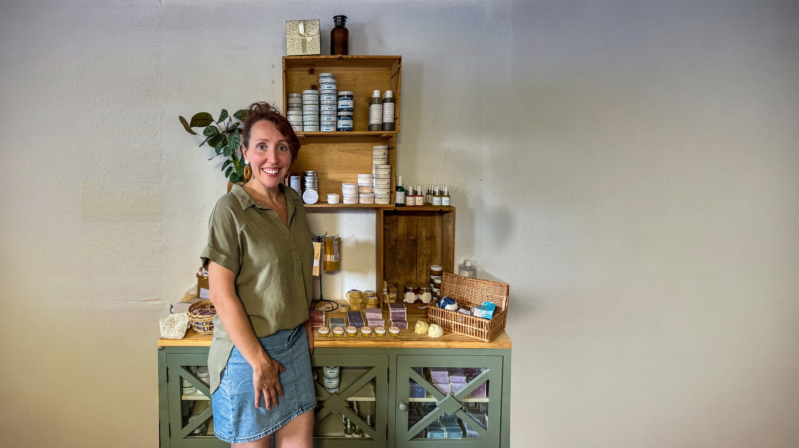 Jessica Masselot dans son atelier Kaly Flore, devant ses étagères de savons et de cosmétiques, format paysage