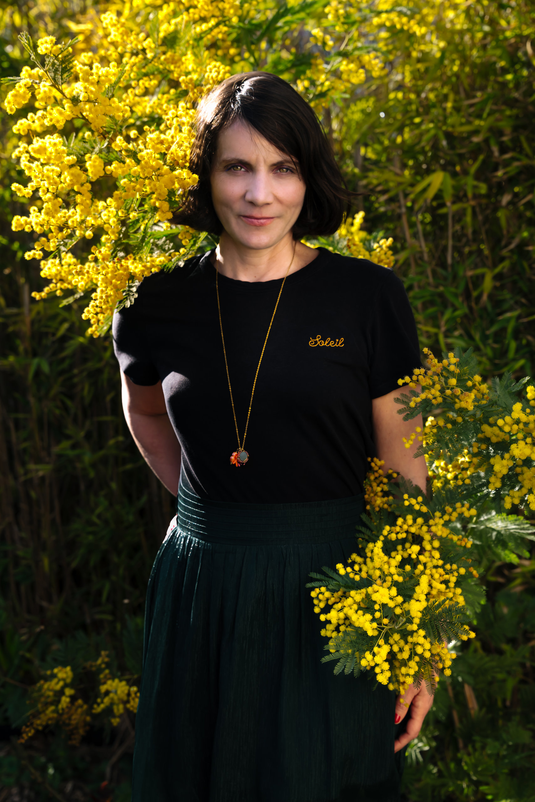 Portrait de Muriel Brunier devant un mimosa en fleurs