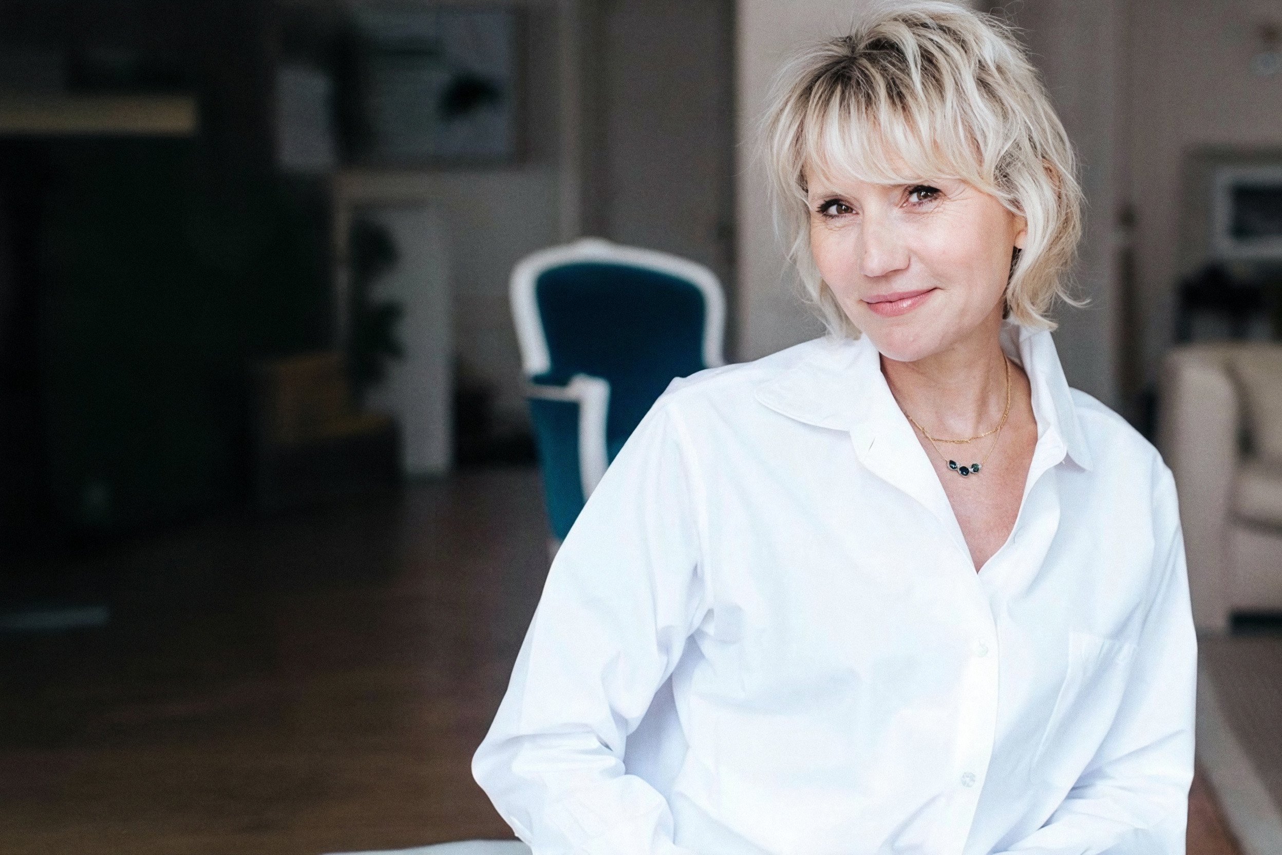 Natacha Dzikowski, chemise blanche, souriante dans un intérieur lumineux, format paysage