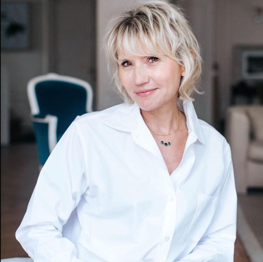 Portrait de Natacha Dzikowski, chemise blanche, souriante dans un intérieur lumineux
