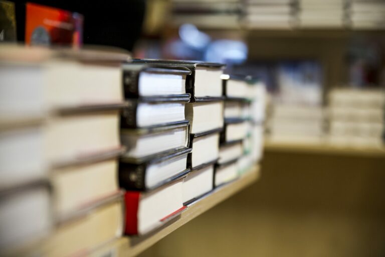Piles de livres alignées sur les étagères en bois d'une librairie