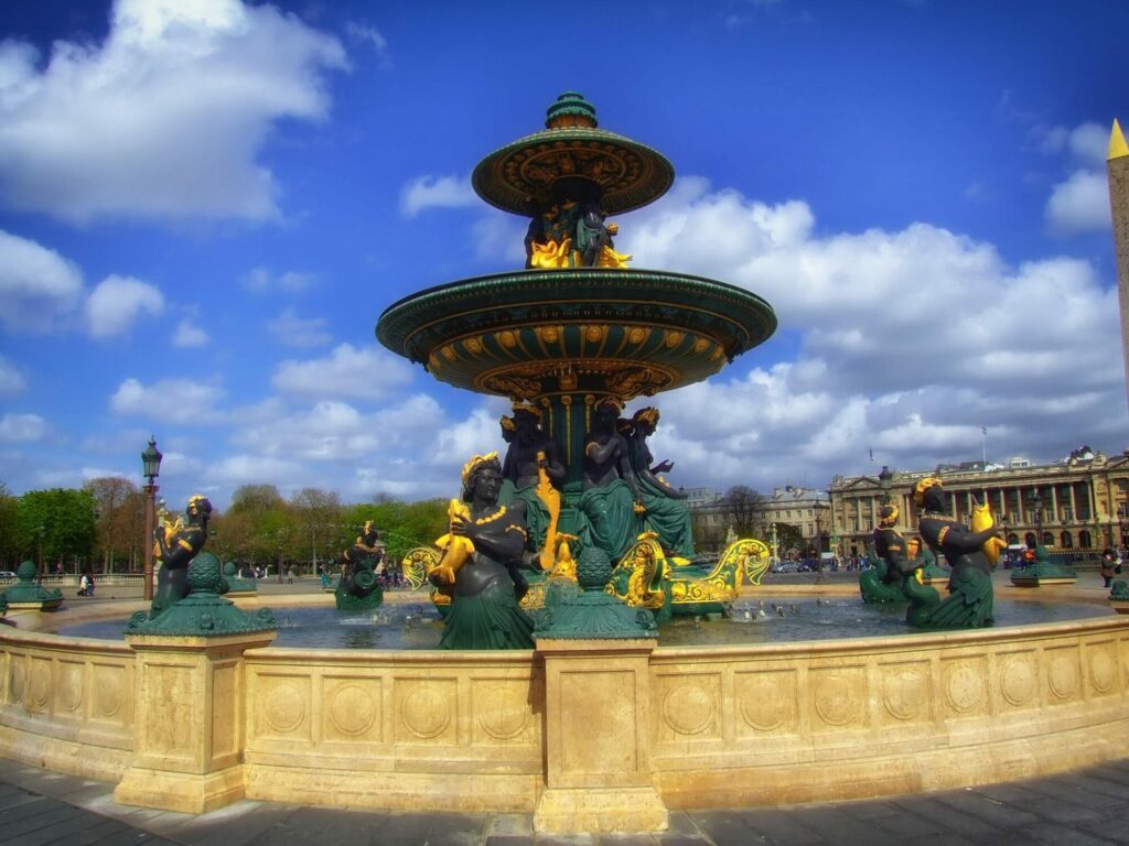 Fontaine des Mers de la place de la Concorde à Paris sous un ciel bleu nuageux