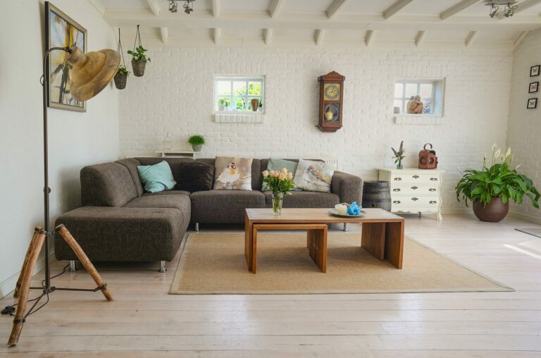 Salon lumineux avec canapé gris, table basse en bois, tapis clair et plantes vertes