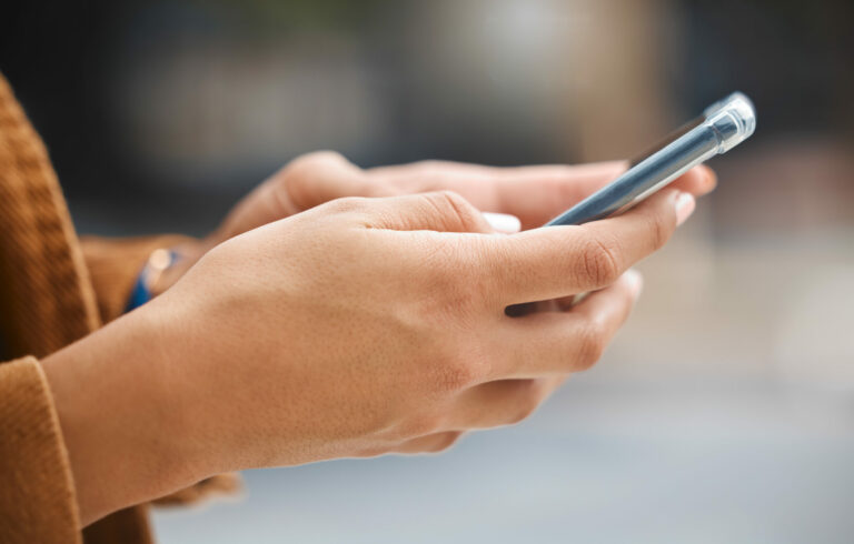 Mains tenant un smartphone, en ville