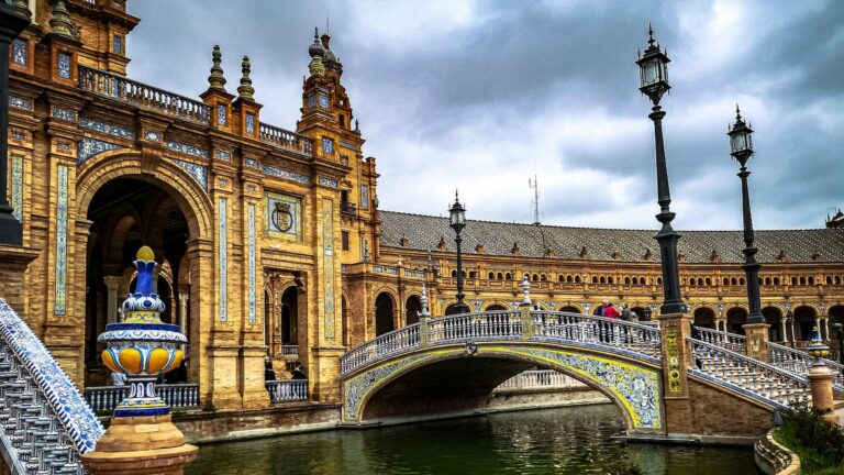 Arcades et pont de la place d'Espagne à Séville sous un ciel nuageux
