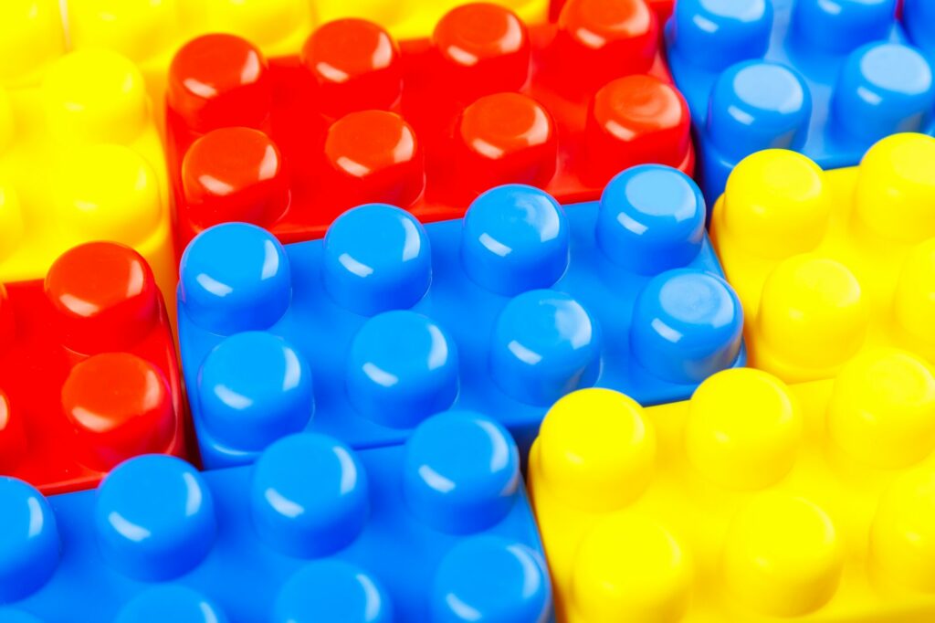 Gros plan sur des briques de construction en plastique rouges, jaunes et bleues emboîtées