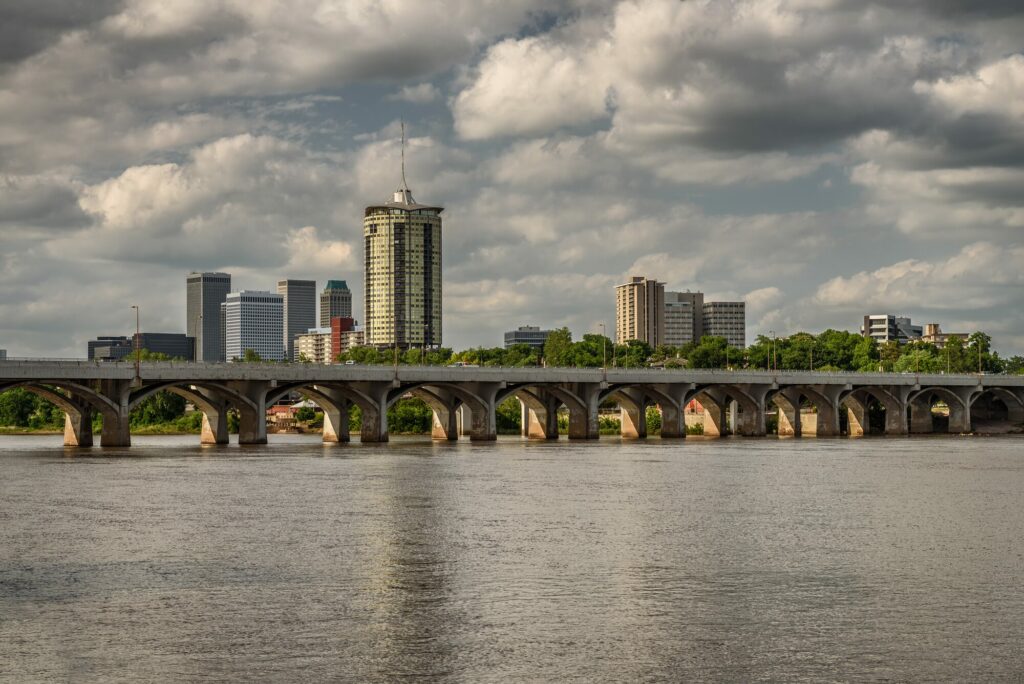Les gratte-ciel du centre de Tulsa dans l'Oklahoma derrière un pont à arches sur la rivière Arkansas, sous un ciel nuageux